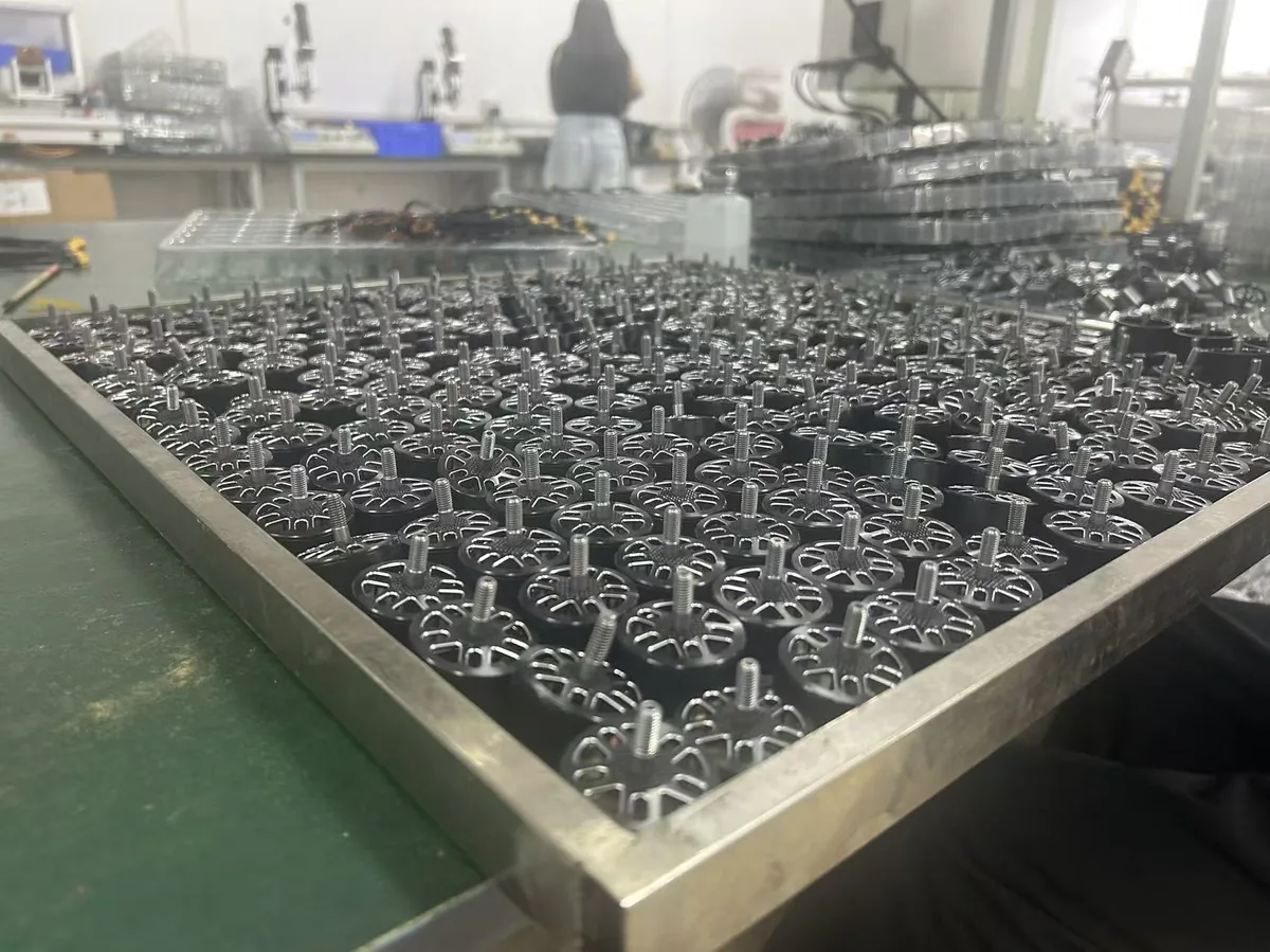 Outrunner motor rotor bells arranged in trays on the Yadovex production line, showing batch manufacturing scale